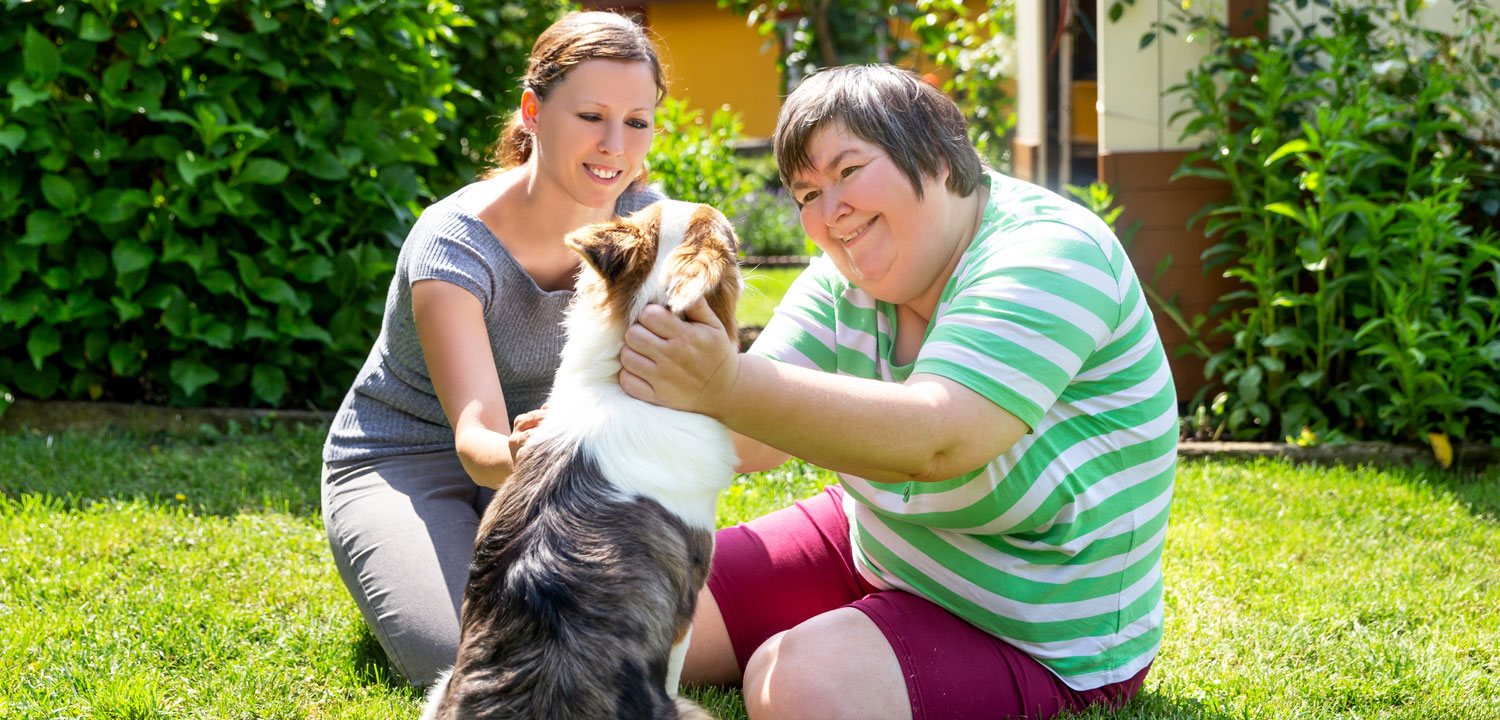 Developmental disabilities adult providing love to a dog